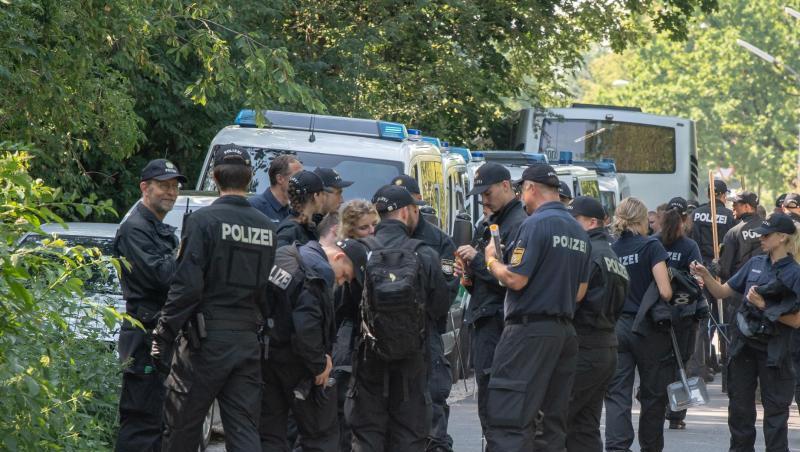 Polizisten sammeln sich auf einer Straße, um anschließend weiter in einem Forst bei München nach zwei Leichen zu suchen. Foto: Peter Kneffel Polizisten sammeln sich auf einer Straße, um anschließend weiter in einem Forst bei München nach zwei Leichen zu suchen. Foto: Peter Kneffel