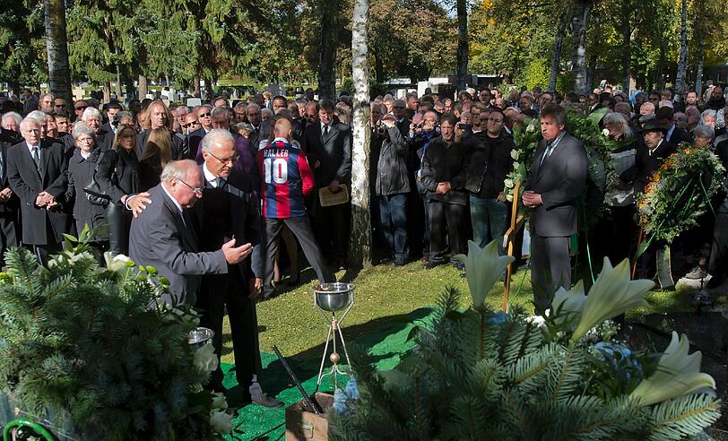 Uwe Seeler (l.) und Franz Beckenbauer stehen am offenen Grab von Helmut Haller.