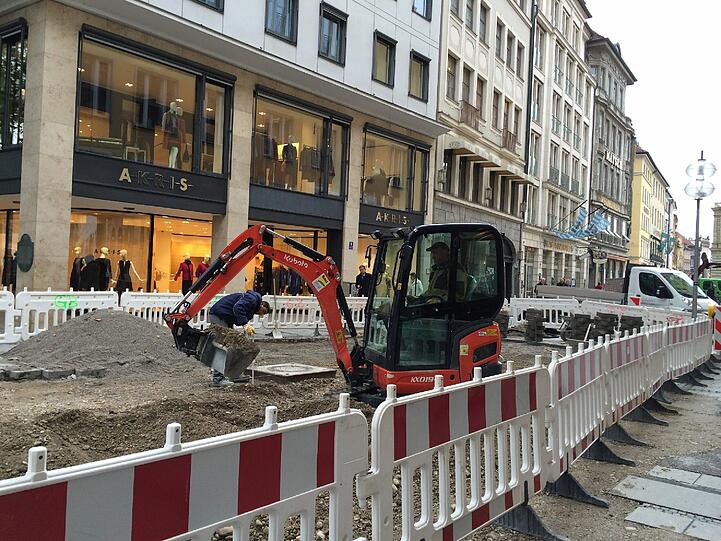 ... verteilt hinter der Sperre den Kies für die neue Straßendecke.