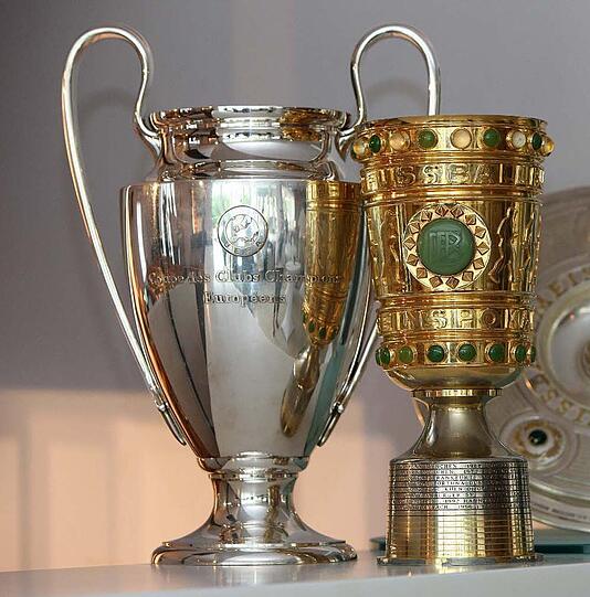 Objekte der Begierde: Der Champions-League-Pott und der DFB-Pokal.