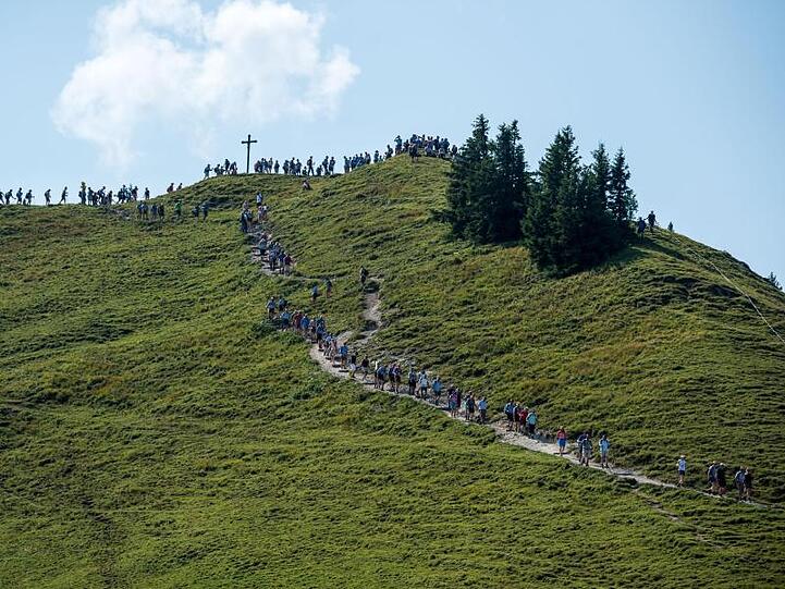 Teilnehmer bei der Hauptalmbegehung gehen vom Gipfel des Baumgartenschneids herunter. Foto: Lino Mirgeler/Archiv