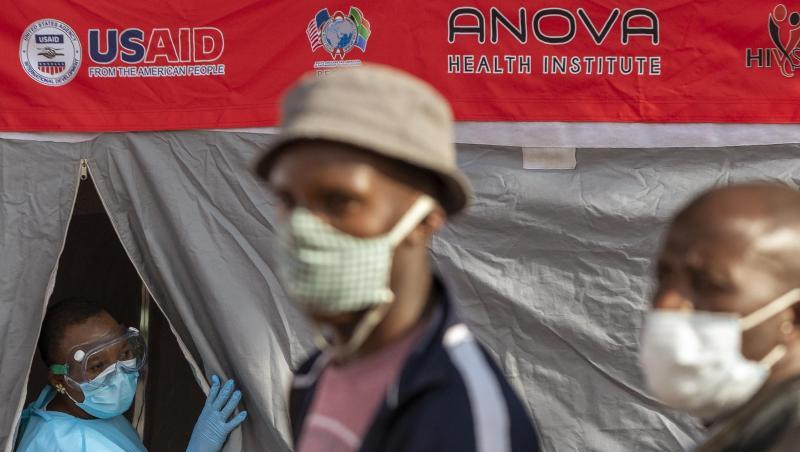 Menschen stehen in Johannesburg vor einem Zelt an, um sich auf eine Infektion mit dem Coronavirus testen zu lassen.