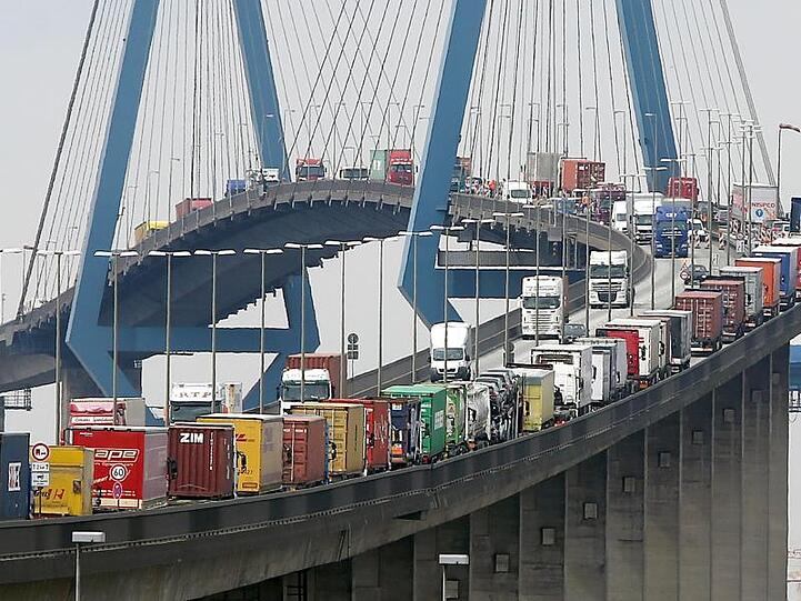 Mit Containern beladene Lastwagen stauen sich auf der Köhlbrandbrücke im Hamburger Hafen.