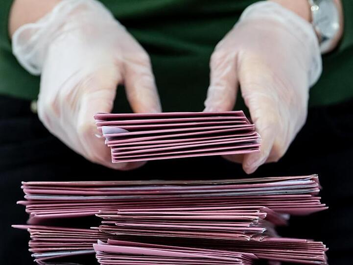 Wahlhelfer bereiten die Auszählung der Briefwahl vor. Foto: Sven Hoppe/dpa