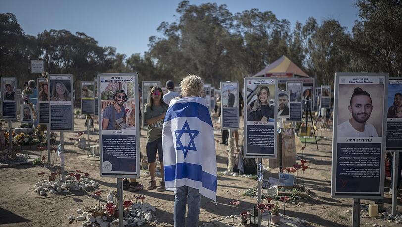Eine Frau trägt die israelische Flagge auf dem Nova-Festplatz während einer Zeremonie zum Gedenken an den zweiten Jahrestag des von der Hamas verübten Anschlags vom 7. Oktober.