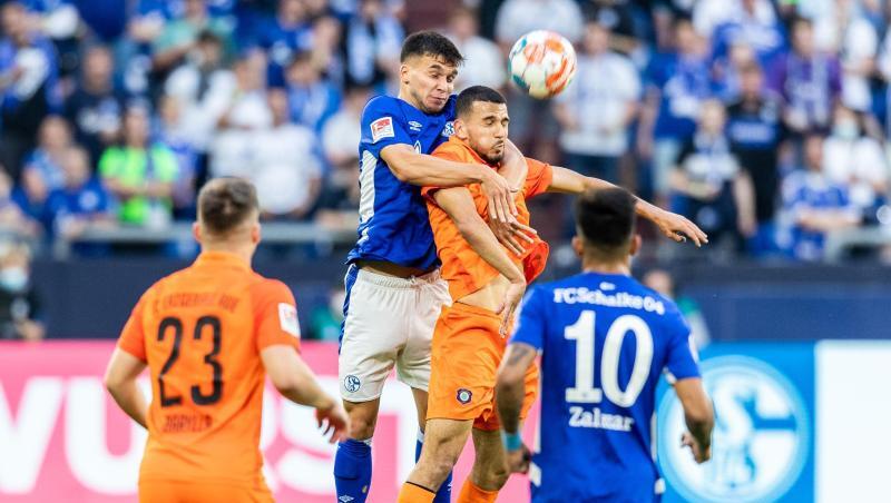Schalkes Mehmet Aydin (2.v.l.) und Aues Soufiane Messequem (2.v.r.) gehen zum Kopfballduell hoch.