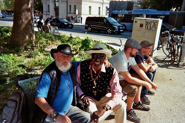 Für diese Szene am Sendlinger-Tor-Platz hat sich der Obdachlose und Kalenderfotograf Mbay Nyuedji (2.v.l.) selbst mit aufs Bild begeben. Es soll zeigen, wie er "den Moment und die Freundschaft" genießt.