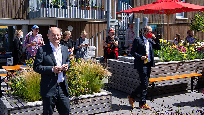 Olaf Scholz (l) besucht bei seinem Aufenthalt in München auch ein genossenschaftlich erschlossenes Wohnquartier und gemeinschaftsorientierte Wohnflächen.