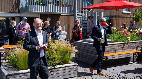 Olaf Scholz (l) besucht bei seinem Aufenthalt in München auch ein genossenschaftlich erschlossenes Wohnquartier und gemeinschaftsorientierte Wohnflächen.