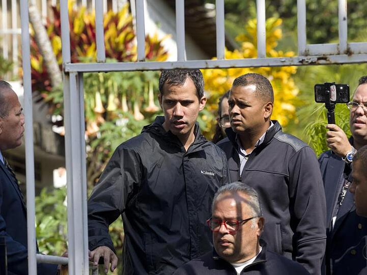 Juan Guaidó (M) in der Nähe des Hauses seines Bürochefs Marrero.