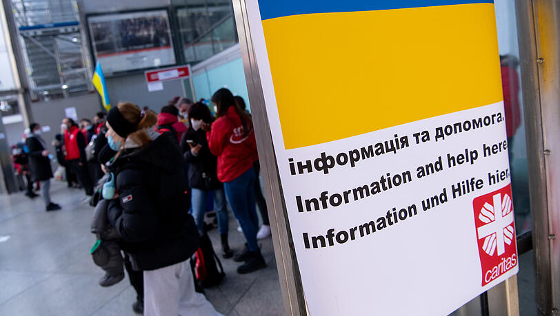 Am Münchner Hauptbahnhof werden Flüchtlinge aus der Ukraine nach ihrer Ankunft von Mitarbeitern der Caritas und freiwilligen Helfern empfangen.