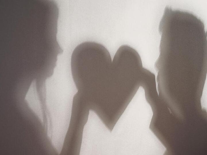 Der Schatten einer Frau und eines Mannes, die gemeinsam ein Herz halten, ist an eine Wand geworfen. Foto: Jan-Philipp Strobel/dpa/Symbolbild