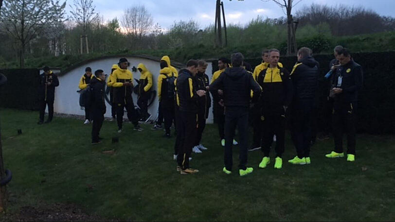 Mitglieder der Fußball-Mannschaft von Borussia Dortmund und des Betreuerstabes stehen am 11.04.2017 in Dortmund in der Nähe eines Hotels um Trainer Thomas Tuchel (M) herum.