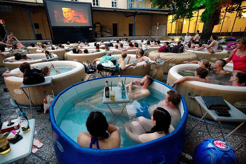 Etwa 150 Menschen sitzen am Freitag in 30 Whirlpools und schauen sich gemeinsam den Film &bdquo;Pulp Fiction&ldquo; an.  Foto: Peter Kneffel/dpa