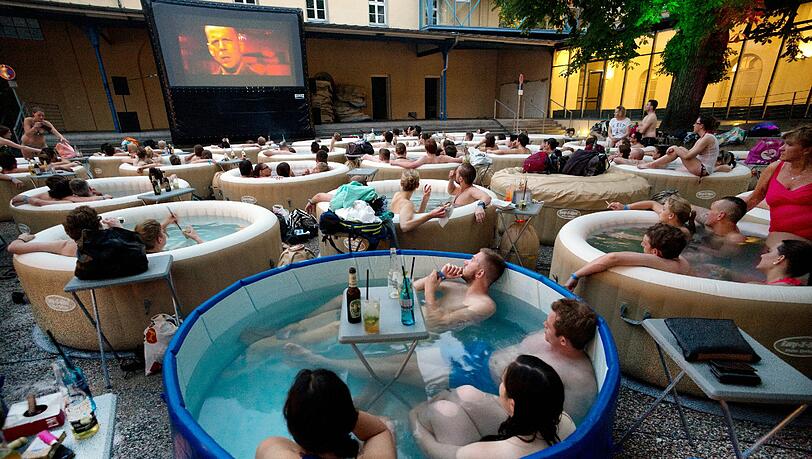 Etwa 150 Menschen sitzen am Freitag in 30 Whirlpools und schauen sich gemeinsam den Film „Pulp Fiction“ an. Foto: Peter Kneffel/dpa Etwa 150 Menschen sitzen am Freitag in 30 Whirlpools und schauen sich gemeinsam den Film „Pulp Fiction“ an. Foto: Peter Kneffel/dpa