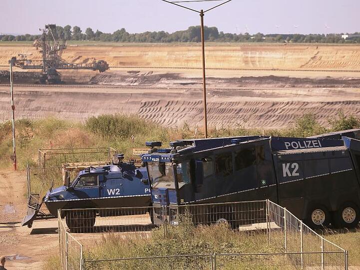 Ein gepanzertes Räumfahrzeug und ein Wasserwerfer am Rand des Braunkohle-Tagebaus Garzweiler.