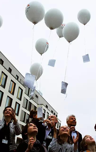 Ehemalige Patienten und Mitarbeiter lassen bei der Eröffnung ihre guten Wünsche für die Klinik an Ballons in die Lift steigen.