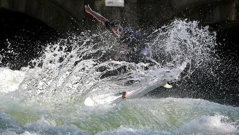 Lässt die Wassertropfen fliegen: Dieser Eisbach-Surfer kann’s. Lässt die Wassertropfen fliegen: Dieser Eisbach-Surfer kann’s.