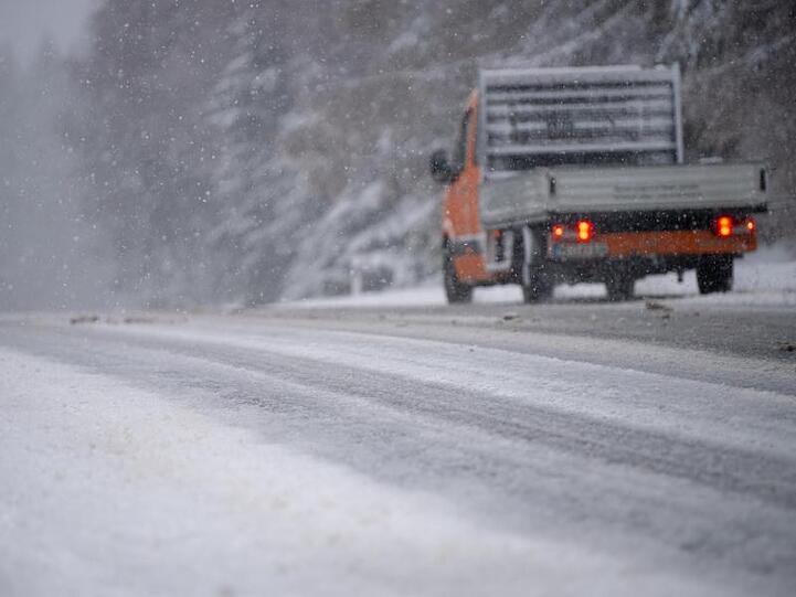 Ein Auto fährt bei dichtem Schneefall über eine Straße. Foto: Monika Skolimowska