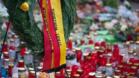 Trauerkerzen und Blumen sowie ein Kranz der Stadt Würzburg liegen jetzt dort, wo es am Freitag zu der Messerattacke gekommen war.