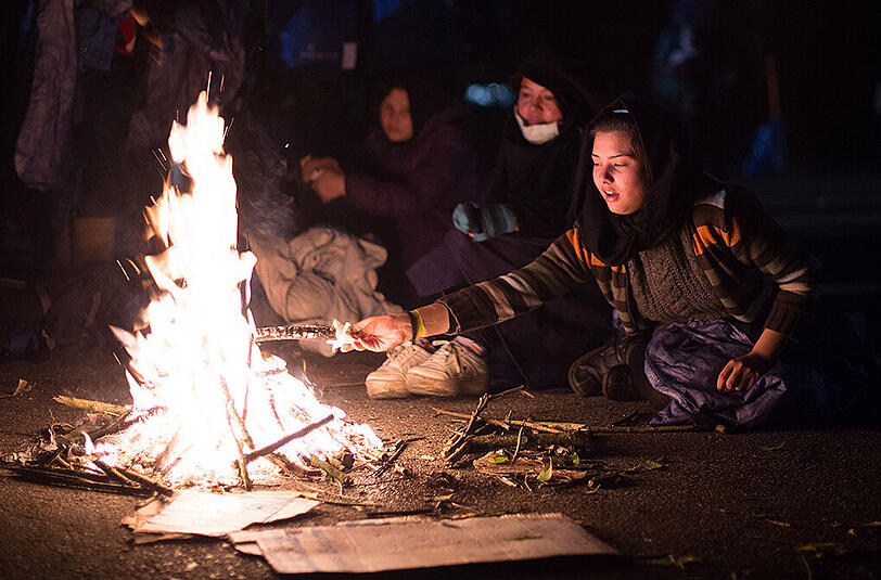 Zwei Frauen aus Afghanistan wärmen sich am nahe Passau an der deutsch-österreichischen Grenze an einem Lagerfeuer.