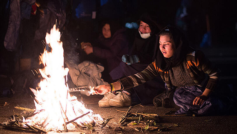 Zwei Frauen aus Afghanistan wärmen sich am nahe Passau an der deutsch-österreichischen Grenze an einem Lagerfeuer. Zwei Frauen aus Afghanistan wärmen sich am nahe Passau an der deutsch-österreichischen Grenze an einem Lagerfeuer.