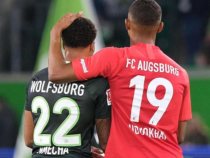 Der Wolfsburger Lukas Nmecha und der Augsburger Felix Uduokhai nach dem Spiel.
