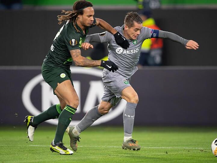 Wolfsburgs Kevin Mbabu (l) versucht St. Etiennes Romain Hamouma zu stoppen.