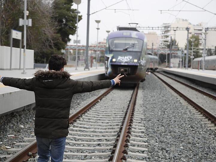 Ein Mann stellt sich auf die Gleise am Bahnhof Athen-Larisa.
