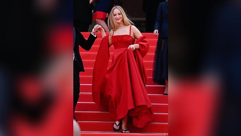 Jennifer Lawrence mit Abendkleid und Flip-Flops auf dem roten Teppich in Cannes.