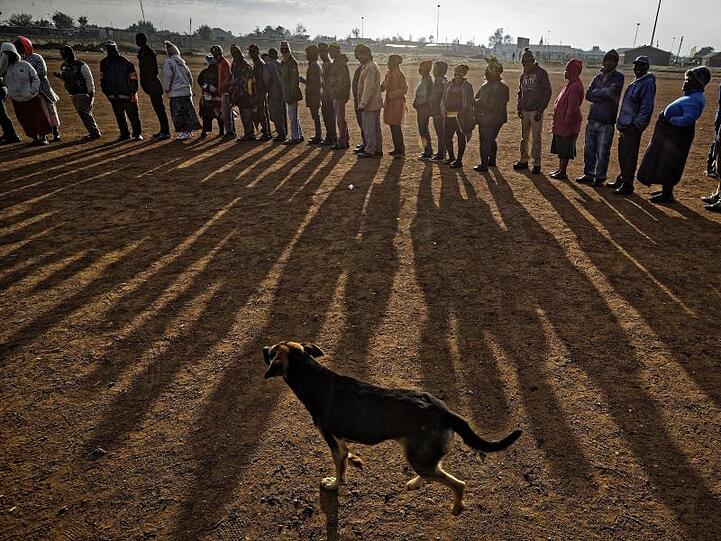 Menschen stehen am frühen Morgen Schlange, um ihre Stimme in der Bergbauregion Bekkersdal abzugeben.