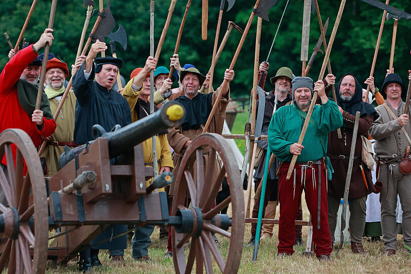 Als Bauern kostümierte Darsteller eines historischen Bauernzuges stehen im Heereslager in Sondershausen zur Nachstellung der Bauernschlacht vor 500 Jahren in Bad Frankenhausen.