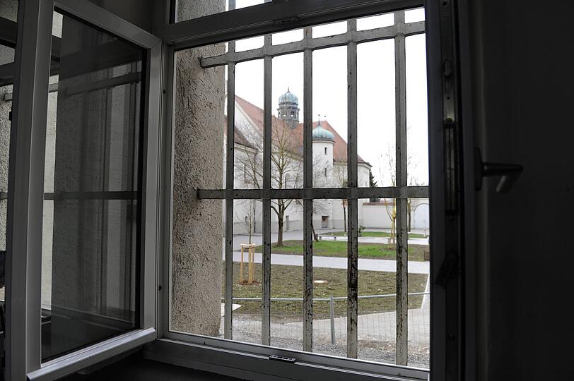 Hinter-Gitter-Blick vom Gefängnisflur nach draußen in den Innenhof