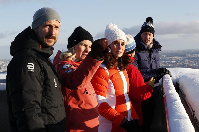 Das Kronprinzenpaar von Norwegen, Haakon und Mette Marit, zeigen Herzogin Kate Prinz William die Holmenkollen Ski Arena. Dicke Winterjacken schützen vor der norwegischen Kälte.