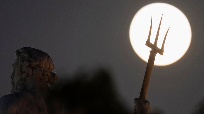 Hinter der Poseidon-Statue in Kopenhagen ist am Himmel ein großer Vollmond zu sehen.