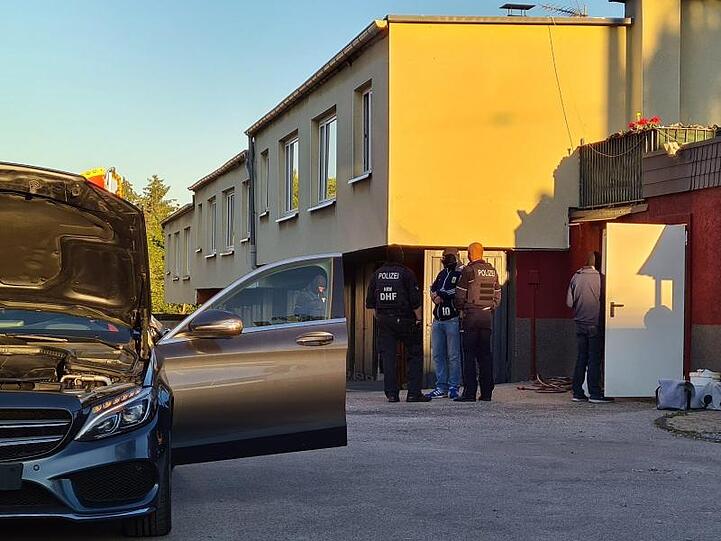 Polizeibeamte stehen auf einem Anwesen. Bei einer Razzia gegen Clankriminalität sind in Nordrhein-Westfalen am frühen Morgen mehrere Wohnungen und Firmen durchsucht worden.
