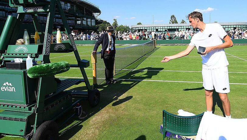 Daniil Medwedew wirft nach seinem Aus in Wimbledon Münzen vor dne Stuhl der Schiedsrichterin. Daniil Medwedew wirft nach seinem Aus in Wimbledon Münzen vor dne Stuhl der Schiedsrichterin.