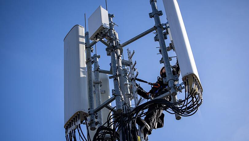 Einer von Zehntausenden Mobilfunk-Masten in Deutschland - hier einer, an dem gerade ein Techniker arbeitet.