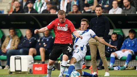 Philipp Ochs (l) von Hannover und Benjamin Goller von Karlsruhe kämpfen um den Ball.