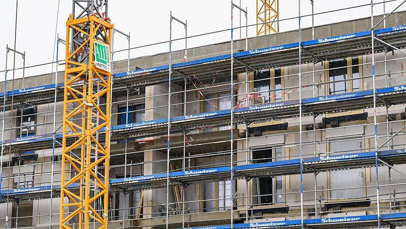 An einem im Bau befindlichen Geb&auml;ude des sozialen Wohnungsbaus sind Fassadenelemente montiert, das Haus ist von einem Bauger&uuml;st umgeben. (Symbolbild)
