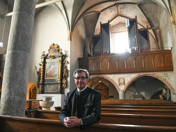 Josef Konitzer, Pfarrer im Pfarrverband Zugspitze, sitzt in der Alten Pfarrkirche. Den Garmischern wird ab Samstag auch nachts wieder die Stunde schlagen. Foto: Angelika Warmuth/dpa/Archiv