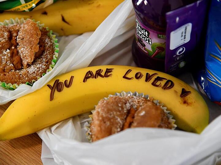 Der britische Prinz Harry und seine Frau Meghan halfen während ihres Besuchs der Hilfsorganisation One25 bei der Vorbereitung von Essenspaketen. Meghan schrieb auf Bananen Mut-Botschaften wie "You are loved" (Du wirst geliebt).