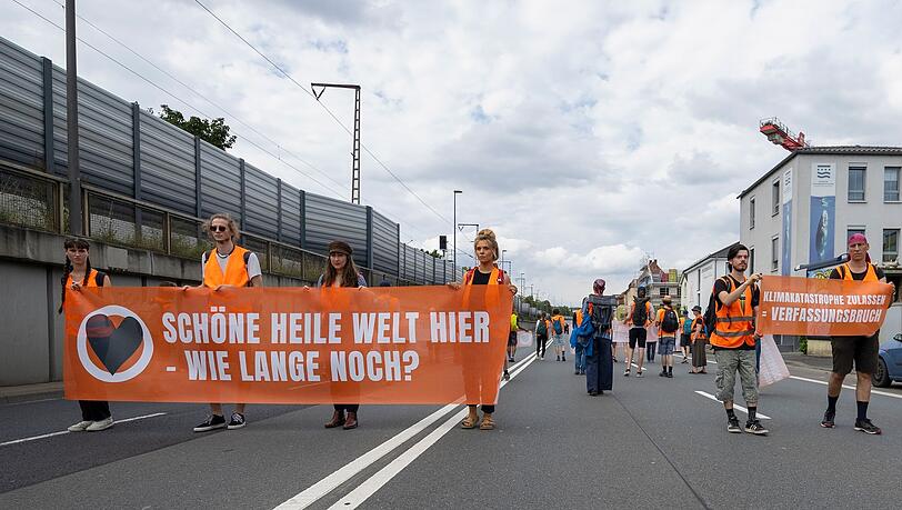 Aktivisten der Klimabewegung Letzte Generation blockieren die Bundesstraße B19 bei Würzburg.
