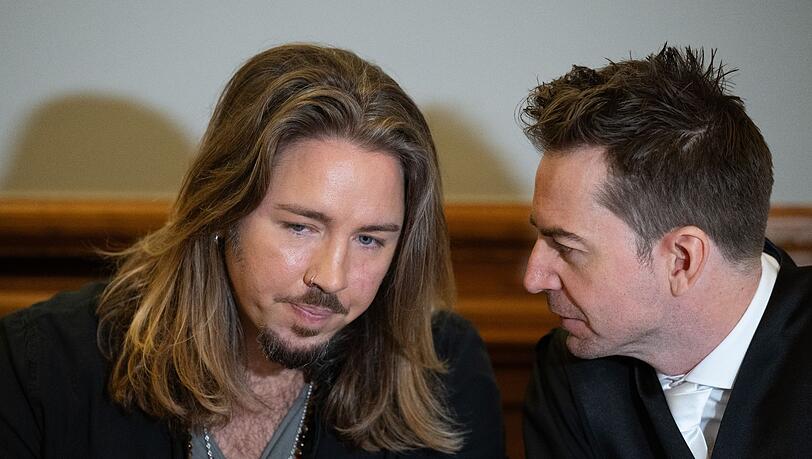 Gil Ofarim (l) unterhält sich im Saal des Landgerichts mit seinem Anwalt Alexander Stevens.