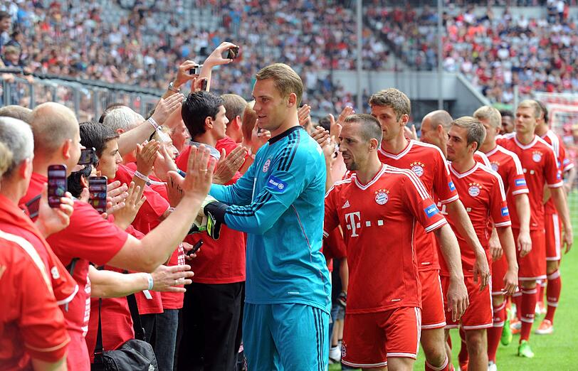 Torhüter Manuel Neuer klatscht mit den Fans ab.