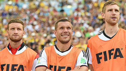 Prominente Bankdrücker: Shkodran Mustafi und Per Mertesacker (rechts) nehmen am Rande des Viertelfinalspiels gegen Frankreich bei der WM 2014 ihren Kollegen Lukas Podolski in die Mitte.