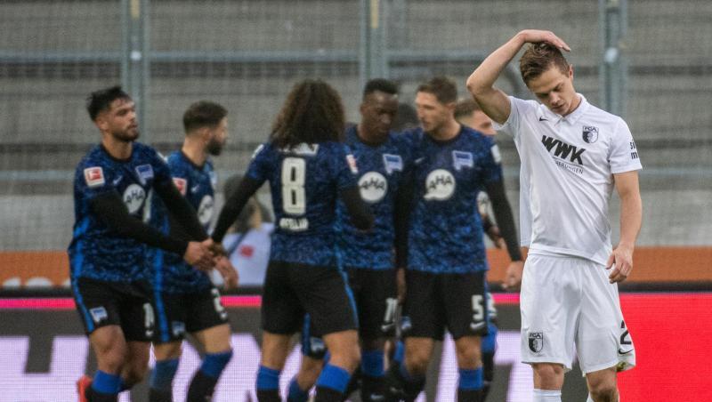 Augsburgs Robert Gumny (r) kann sich nur an den Kopf fassen. Hertha BSC gelingt in Augsburg ein ganz wichtiger Auswärtssieg.