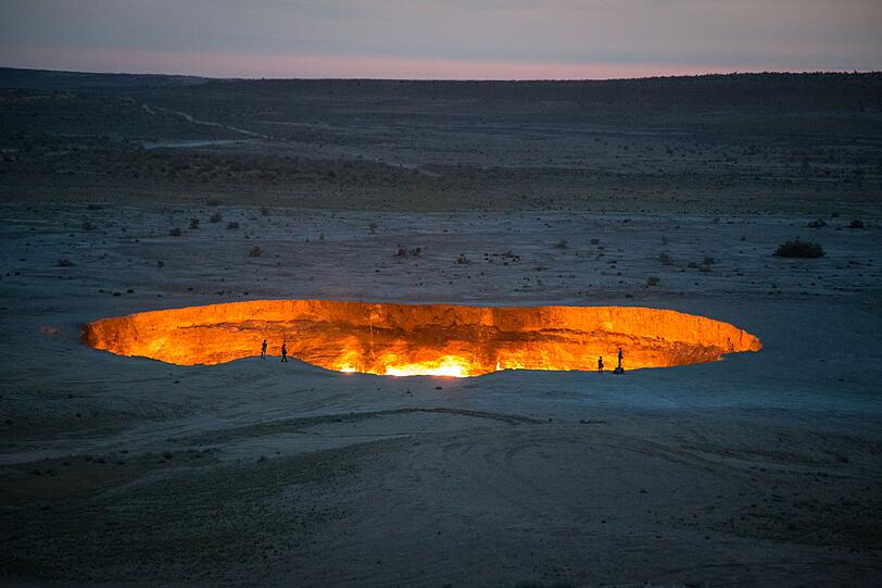 Der Derweze-Krater in Turkmenistan tr&auml;gt seinen Beinamen "Tor zur H&ouml;lle" zu Recht: Seit &uuml;ber 50 Jahren lodern hier ununterbrochen Flammen aus einem gewaltigen Erdgasloch mitten in der Karakum-W&uuml;ste. Inzwischen verhindert ein Sicherheitszaun, dass neugierige Besucher dem hei&szlig;en Abgrund zu nahe kommen und in die "H&ouml;lle" hinabst&uuml;rzen.