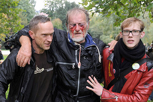 Zwei Männer stützen am Donnerstag (30.09.2010) im Schlossgarten in Stuttgart einen verletzten Mann.