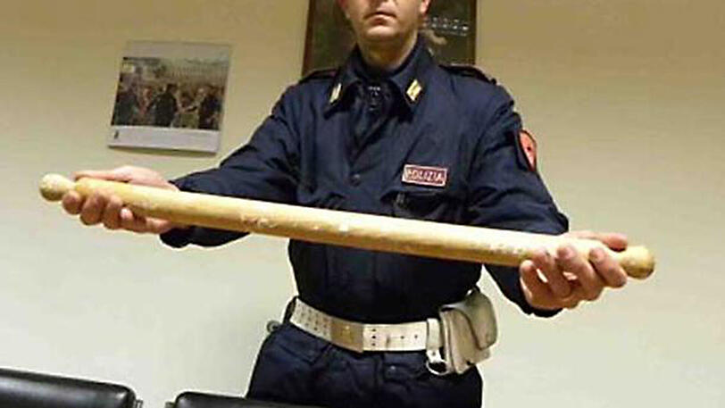 Ein Polizist zeigt das Nudelholz, mit dem der 50-Jährige auf seine Frau einschlug.